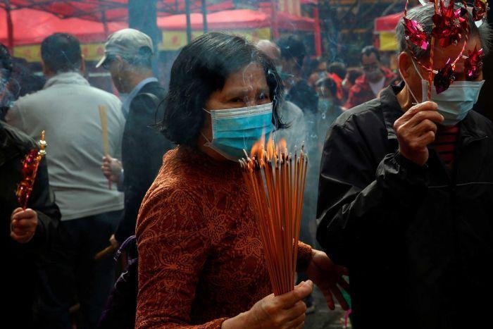 Worshippers wear masks as they make offerings during a Lunar New Year celebration in Hong Kong