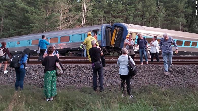 Passengers surround the derailed train